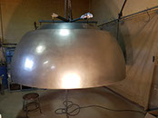 large/oversize light reflector polished to reveal reflective paint surface, simulating the appearance of naturally aged/patina bronze.