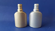 Glass nail polish bottles spray painted with liquid paint that resemble gold and silver metals when cured.