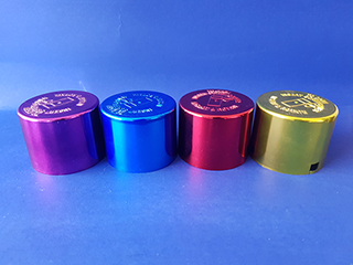 Plastic spray paint lids metalized prior to recieving sprayed liquid topcoat in various colors. Vacuum Metallizing Limited jpg